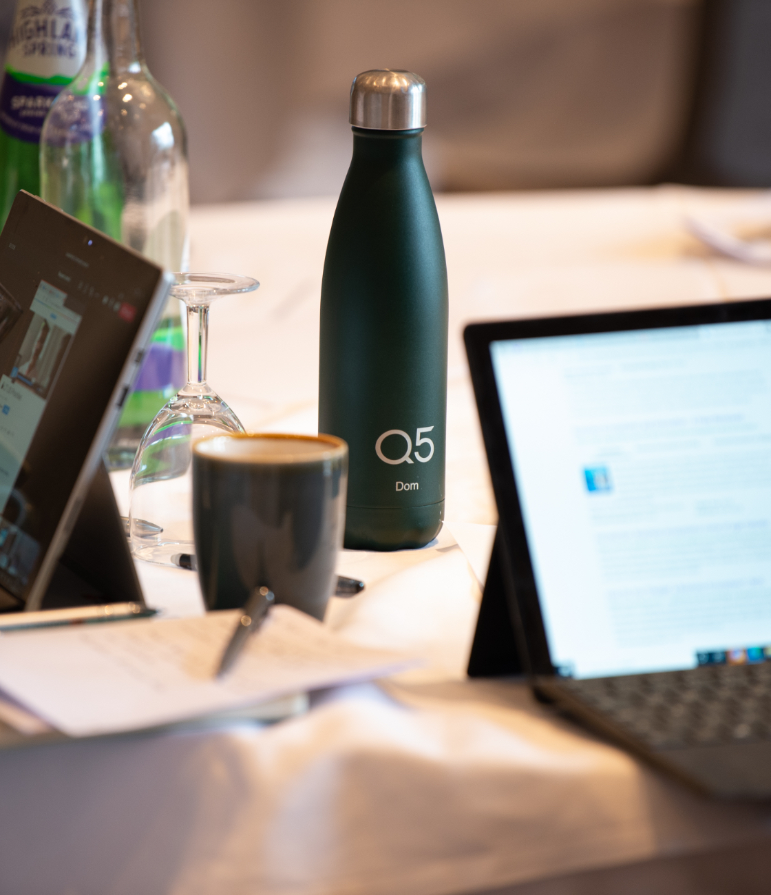 Read Q5's thought piece on organisational health. Q5 green bottle and papers surrounding.